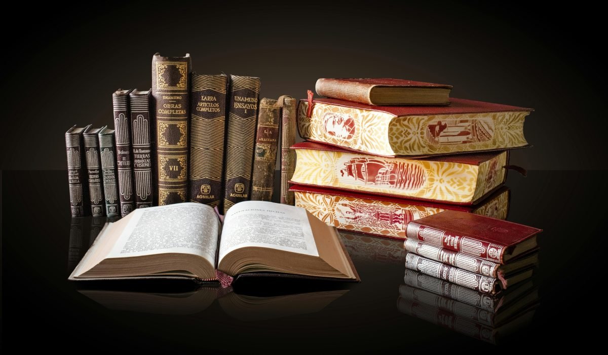 A collection of vintage books displayed elegantly on a reflective surface, ideal for education and literature themes.